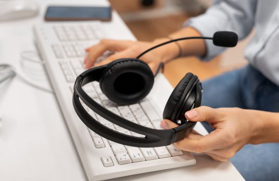 woman-working-call-center-holding-pair-headphones